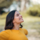 Mujer feliz, con los brazos abiertos, viendo hacia el cielo