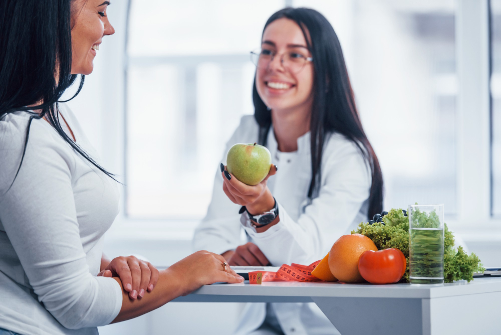 Mujeres platicando acerca de la alimentación y moctrando unas frutas