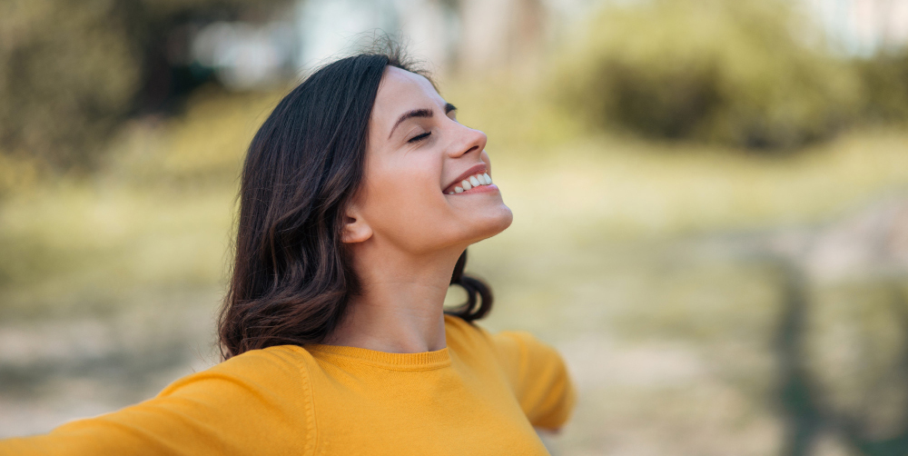 Mujer joven, feliz con los brazos abiertos