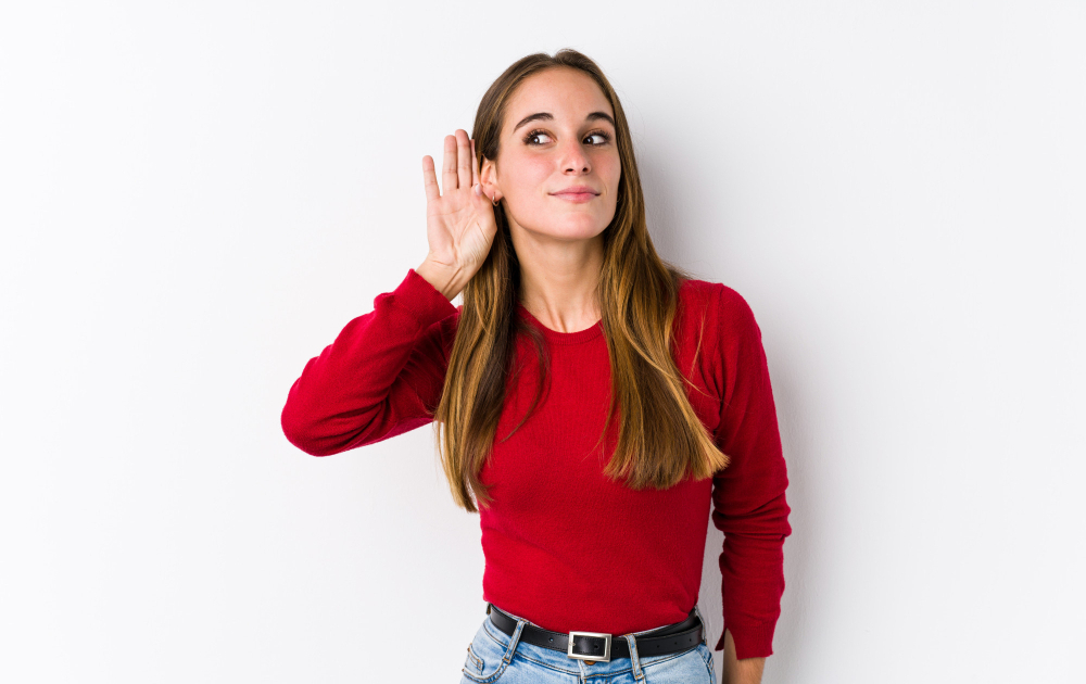Mujer con mano en oído