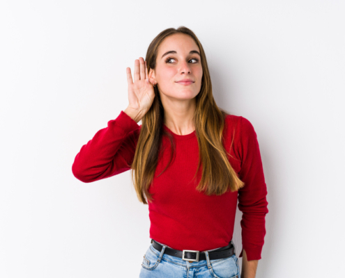 Mujer con mano en oído