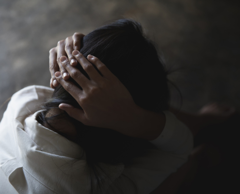 Mujer detrimida, cubriéndose la cabeza