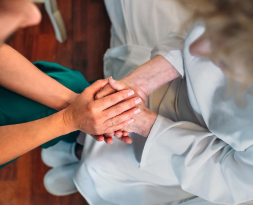 Personas en escena médica tomándose de las manos