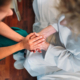 Personas en escena médica tomándose de las manos
