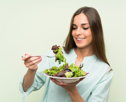 Mujer joven comiendo ensalada