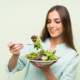 Mujer joven comiendo ensalada