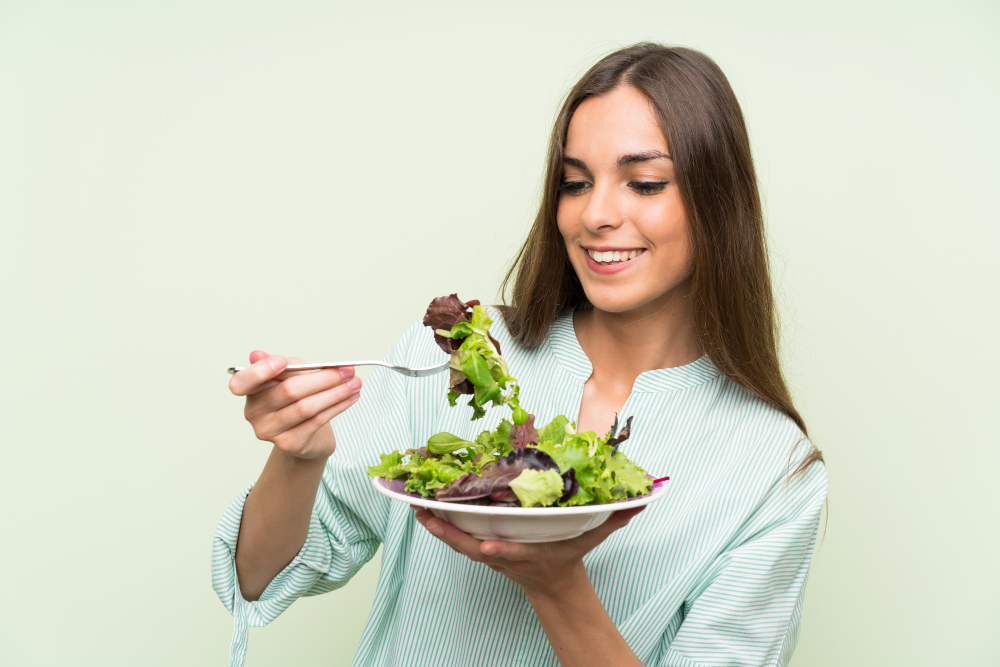 Mujer joven comiendo ensalada