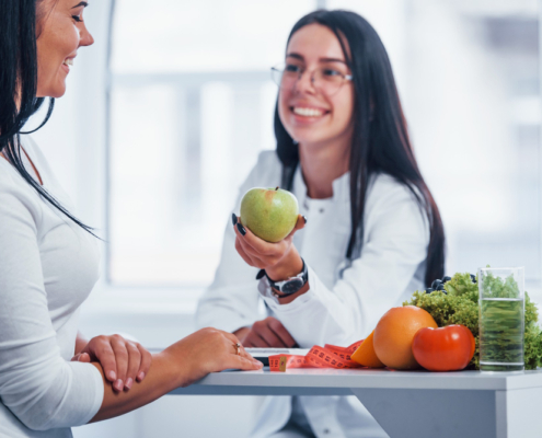 Mujeres platicando acerca de la alimentación y moctrando unas frutas