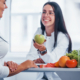 Mujeres platicando acerca de la alimentación y moctrando unas frutas